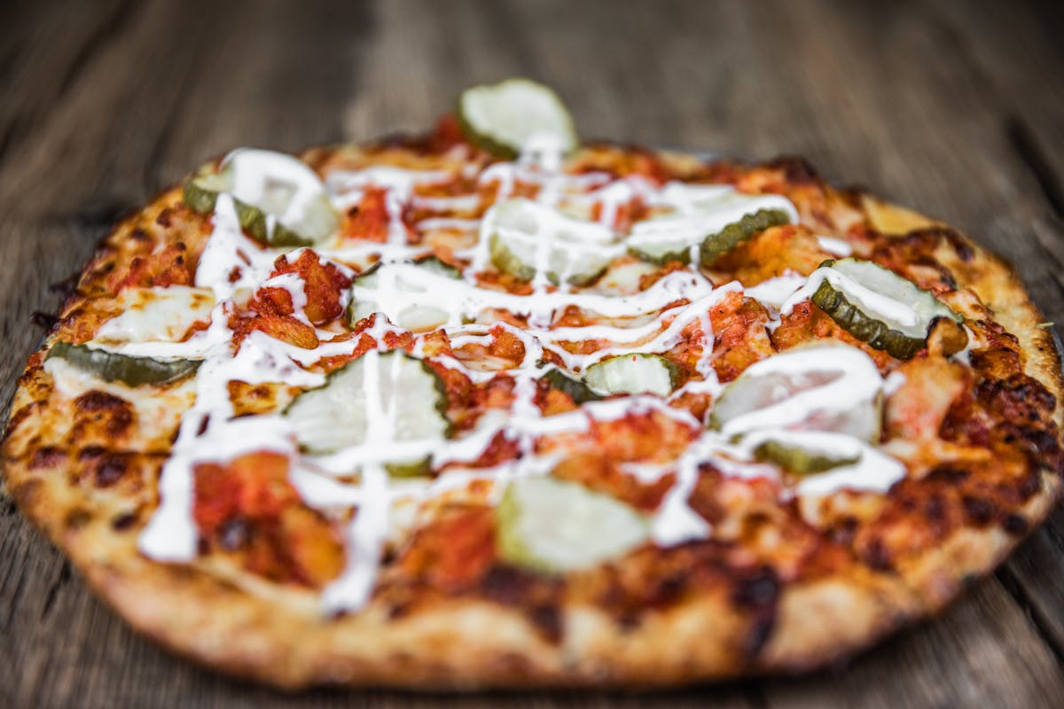 a pizza sitting on top of a wooden cutting board